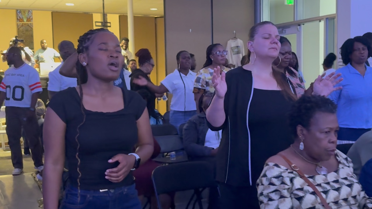 PIWC Bay Area members praying with hands raised